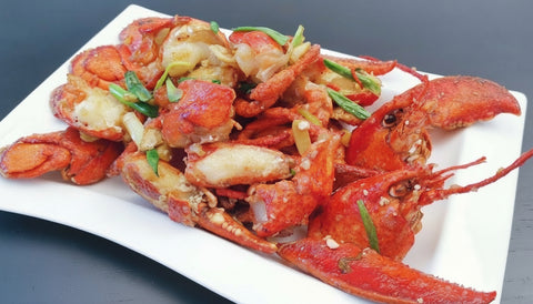 Ginger Scallion Lobsters on a white plate with text overlay